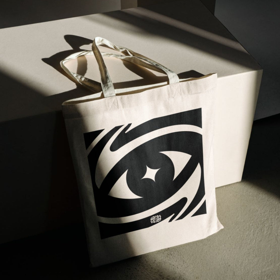 Tote bag with eye design on a dark surface